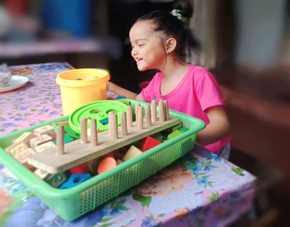 Clydelle enjoying daycare. Access to rehabilitation services means that little Clydelle can now talk, draw, and walk on her own. 